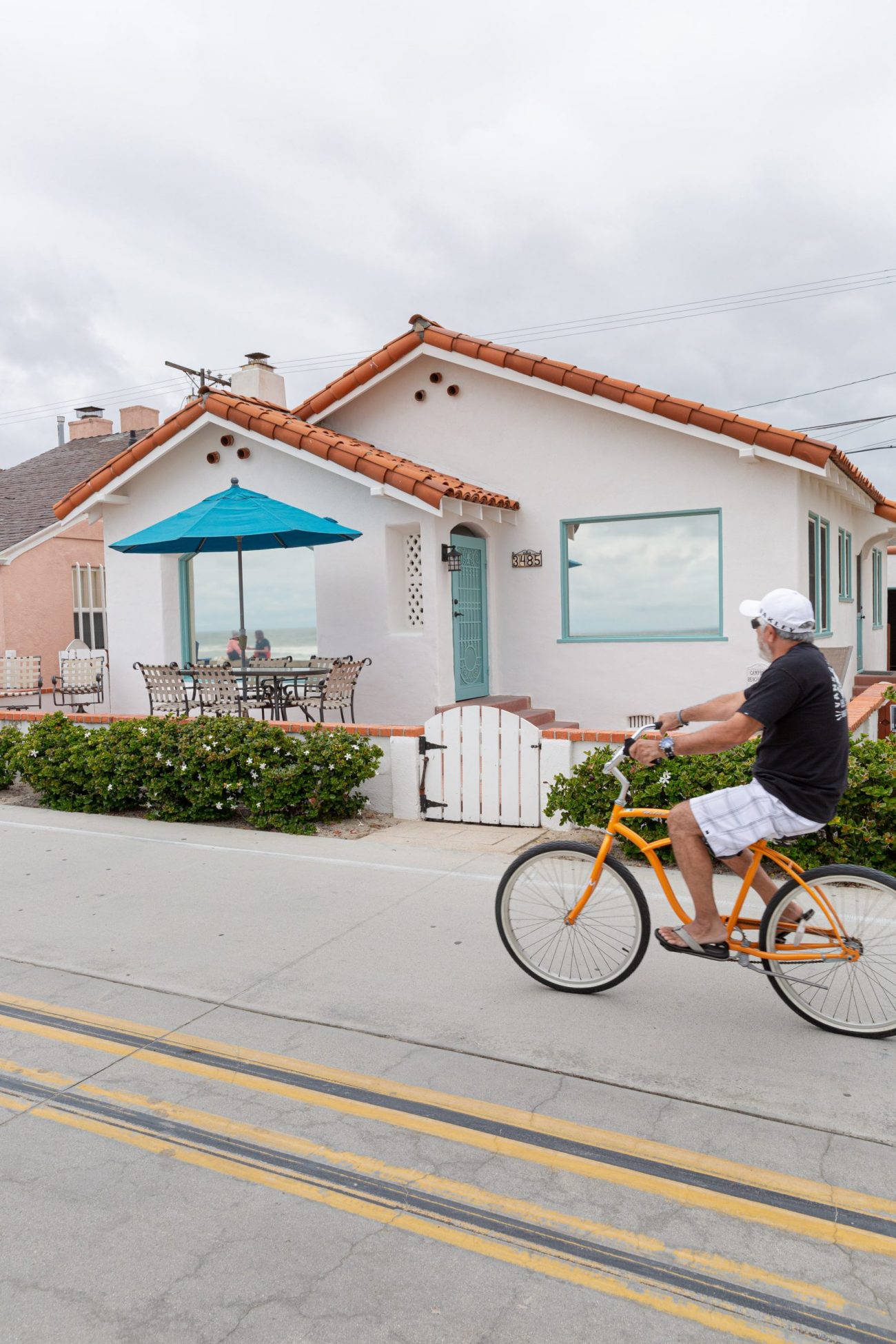 man riding a bike by the house